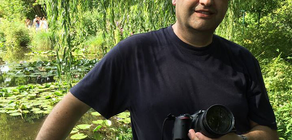 El artista Miguel De Lanu con cámara en mano en los Jardines de Claude Monet en Giverny, Francia, el sitio de inspiración de los Nenúfares.