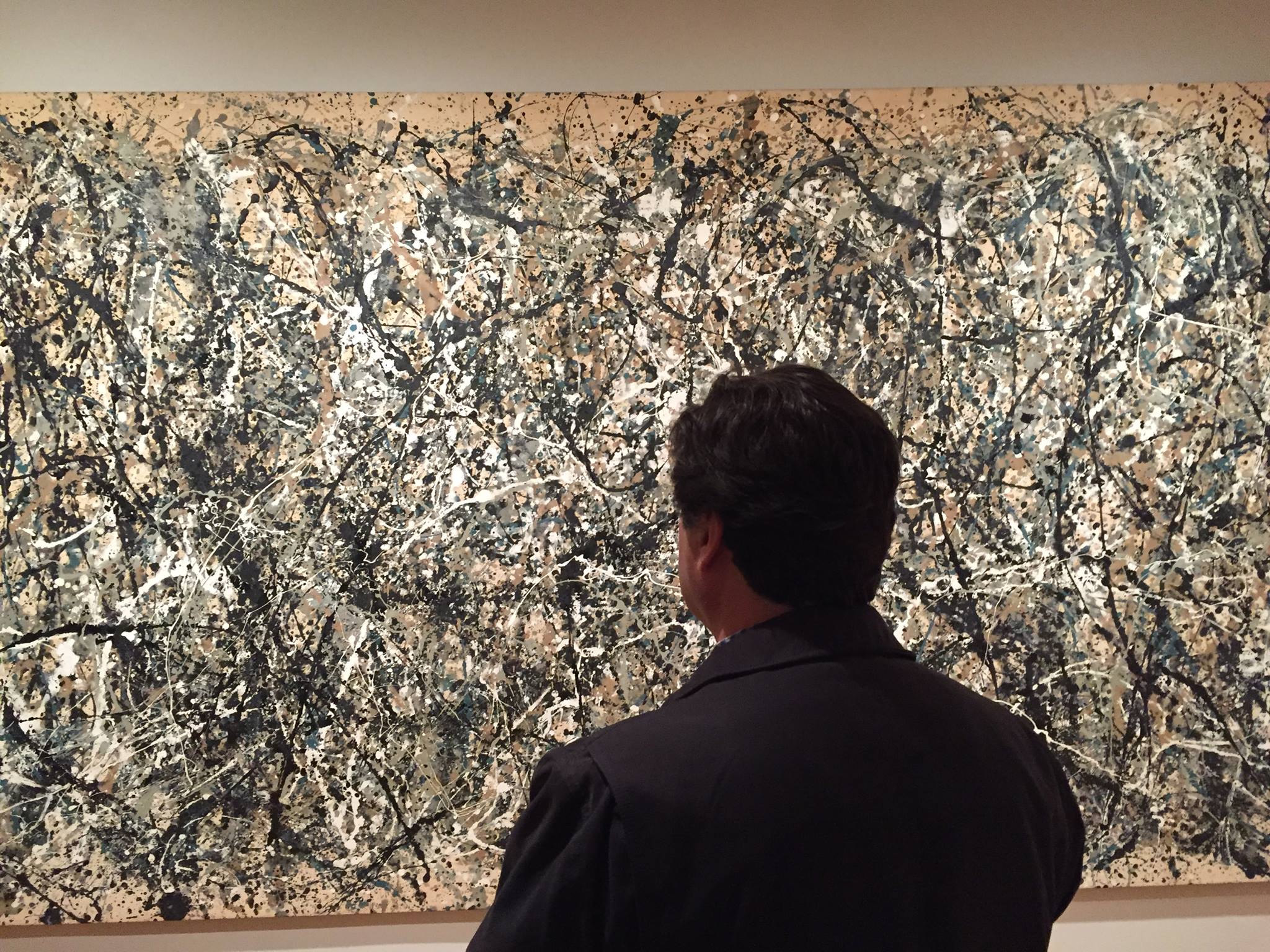 El artista Miguel De Lanu observa una obra de Jackson Pollock en el Museo MoMA de Nueva York, demostrando su interés en el arte moderno.