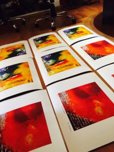 Detalle de la serie de grabados digitales del artista chileno Miguel De Lanú, mostrando cuatro obras con predominio de colores rojos y amarillos.